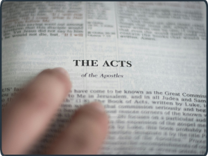 Nahaufnahme einer Bibelstelle in der Apostelgeschichte mit einer Hand im Vordergrund – Symbol für gelebten Glauben und praktische Theologie